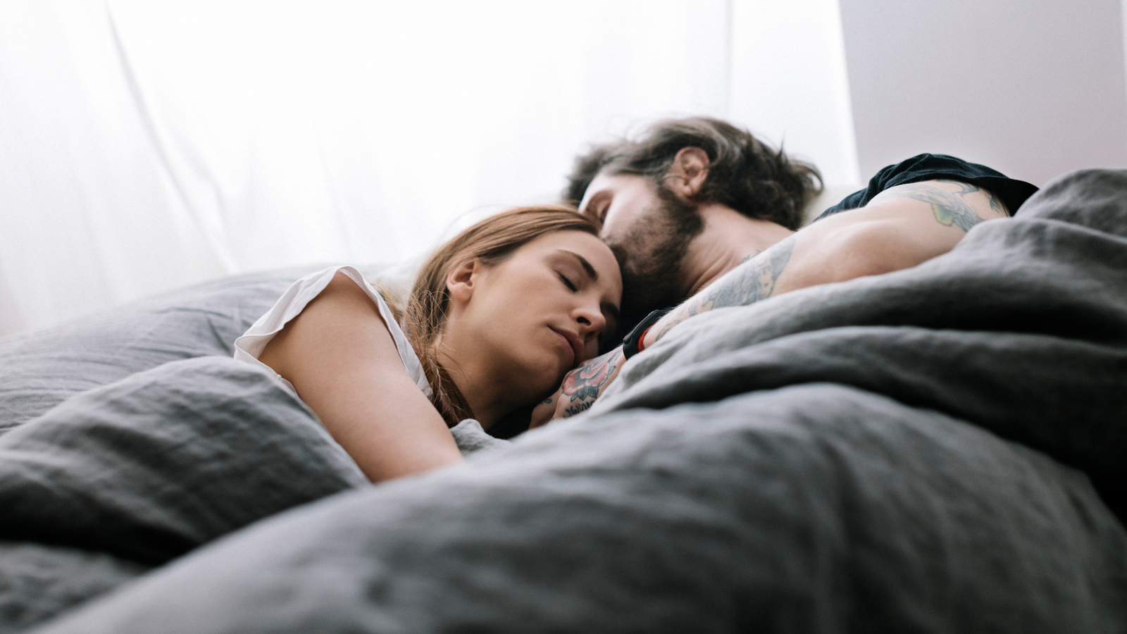 A couple sleep in bed together